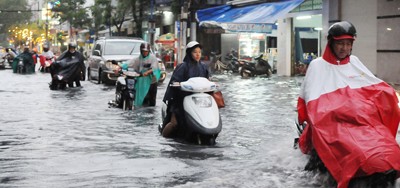City people had to wade through deep floodwaters following heavy rain in HCMC on July 3 (Photo: SGGP)